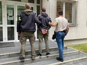 dwaj policjanci CBZC prowadzą zatrzymanego mężczyznę