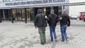 dwaj policjanci CBZC prowadzą zatrzymanego mężczyznę